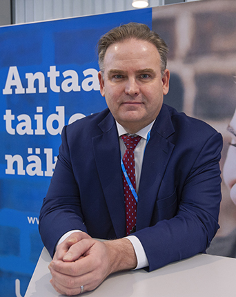 The headmaster of Ylä-Savo municipal federation of education Kari Puumalainen is leaning on the table.