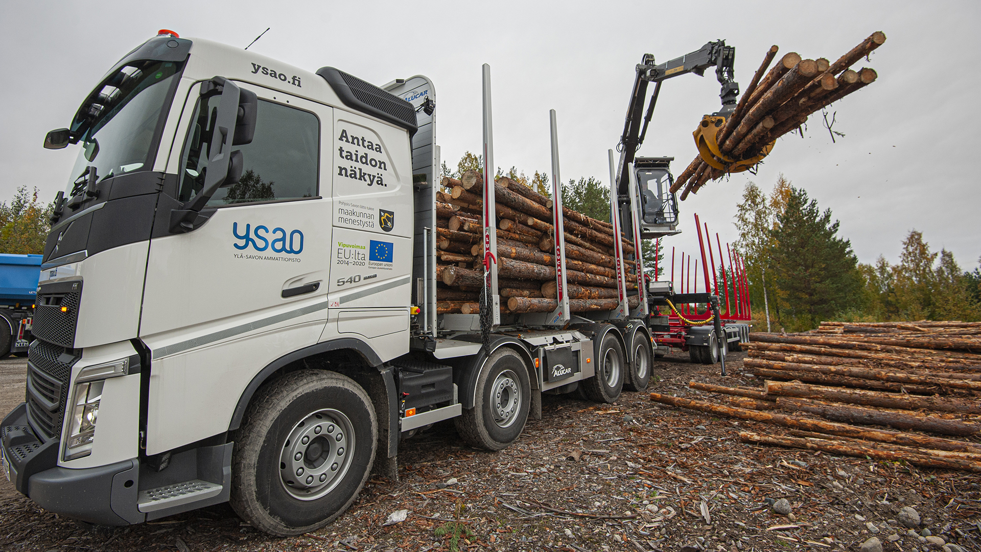 Kuljetusalan ammattitutkinto, metsäteollisuuden kuljetusten osaamisala -opiskelija kuormaamassa puutavara-autoa metsäautotien varressa.