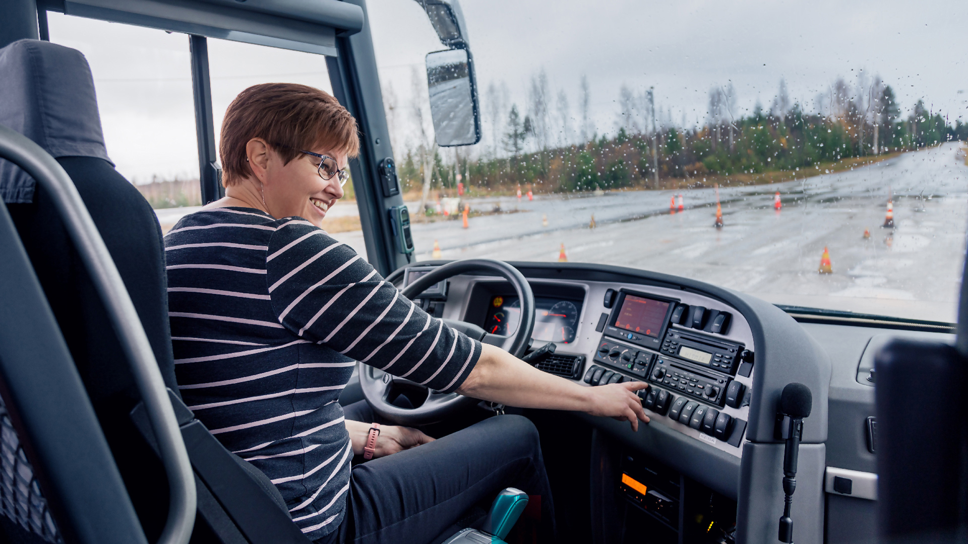 Kuljetusalan ammattitutkinto, henkilökuljetusten osaamisala, linja-autonkuljettaja-opiskelija linja-auton ratissa ajoharjoitteluradalla Ylä-Savon ammattiopiston logistiikka-alan oppimisympäristössä.