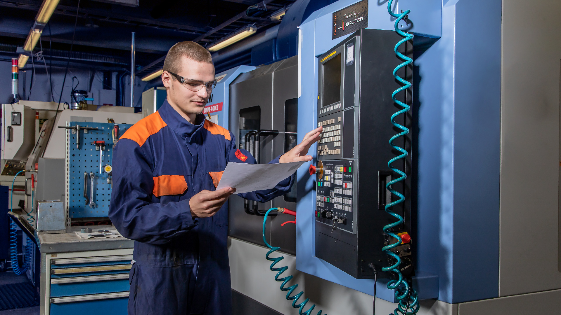 Koneistaja ohjelmoimassa CNC-työstölaitetta Ylä-Savon ammattiopiston teknologia-alan oppimisympäristössä.