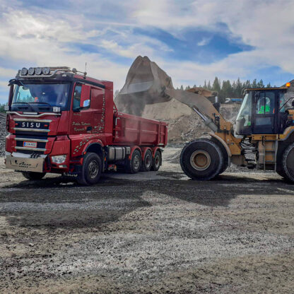 Infra-alan työnjohtokoulutukseen osallistuneet lastaavat maa-ainetta kuorma-autoon.