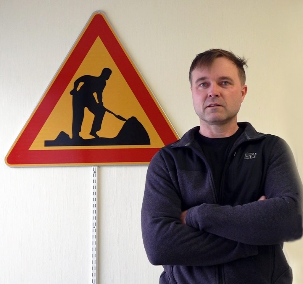 Henkilö seisoo sisällä. liikennemerkki taustalla.