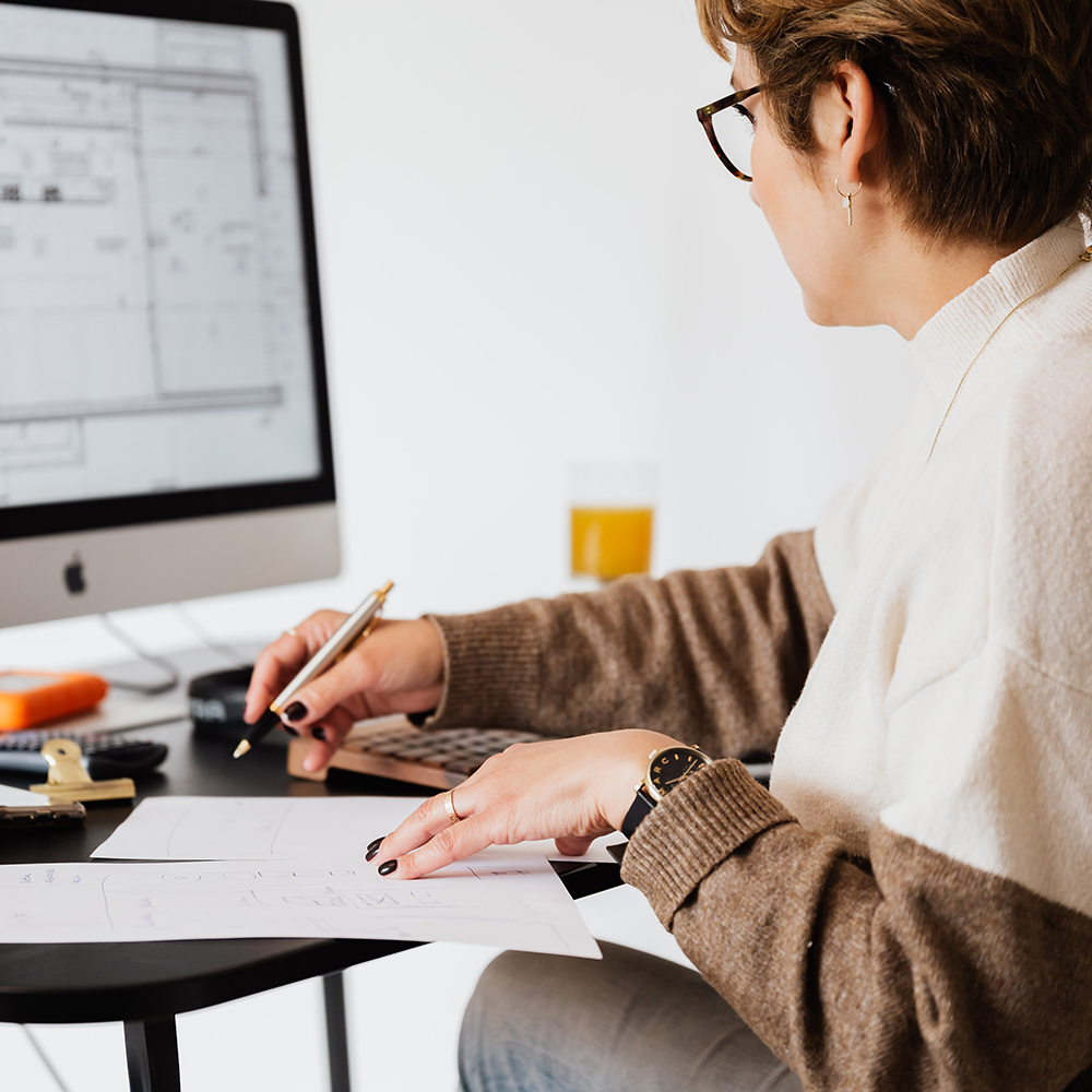 Isännöintialan tutuksi starttikoulutus. Isännöitsijä tutkiin talon piirustuksia.